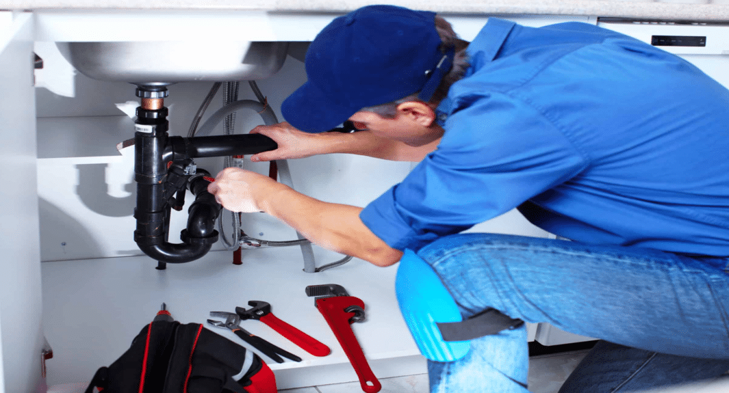 Plumber repairing kitchen plumbing.